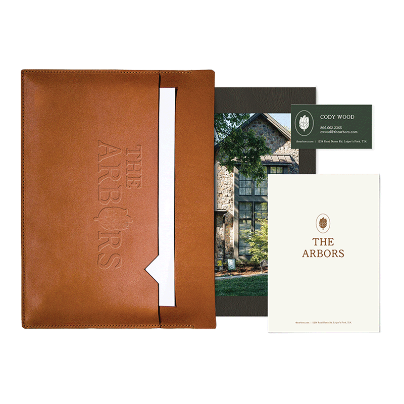 Luxury estate collateral mockup displaying a branded leather portfolio, stationery, and premium property showcase brochure.