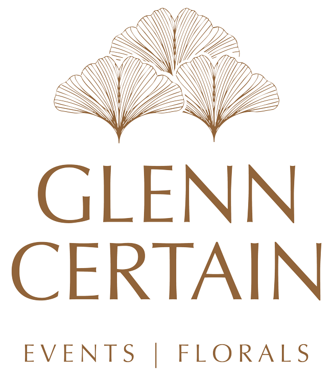 Vertical stacked color logo variation for a Glenn Certain featuring a custom ginkgo leaves graphic.